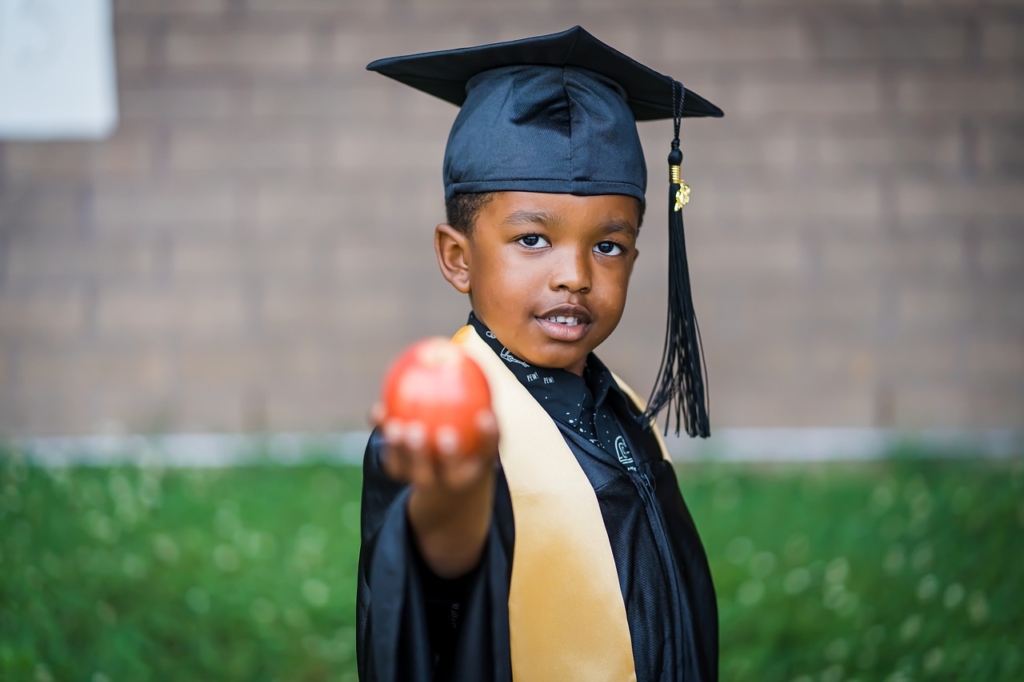 Prek graduate holding an apple